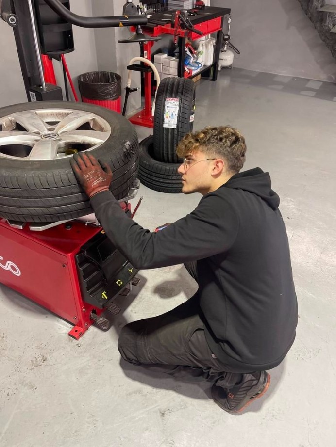 Operario de pneumáticos Toni reparando un pinchado de una rueda usando una maquina roja de la marca teco